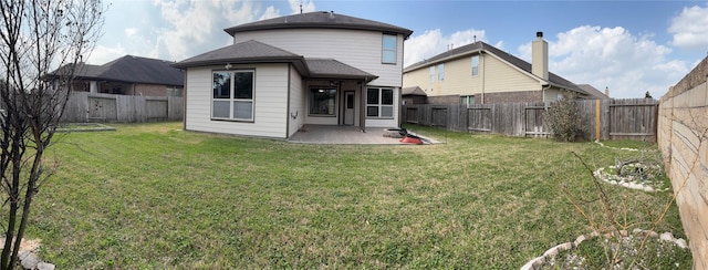 back of property with a yard, a patio area, and a fenced backyard