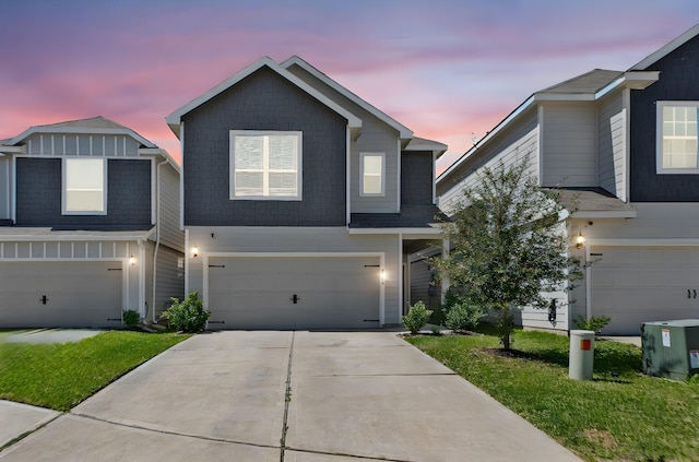 traditional-style house featuring a yard, concrete driveway, and an attached garage