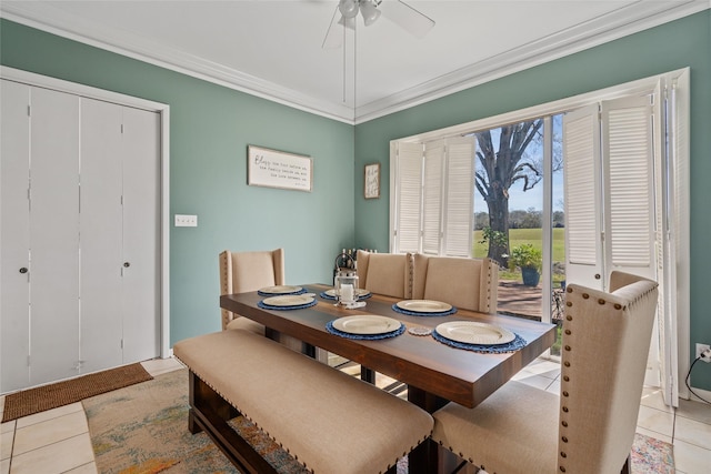 dining space featuring a ceiling fan, light tile patterned flooring, and crown molding