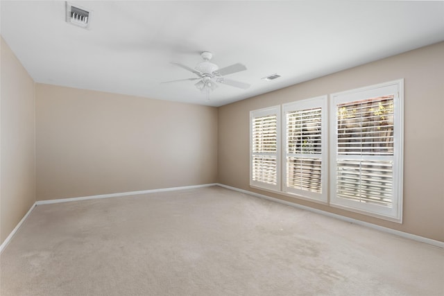 spare room with carpet floors, baseboards, and visible vents