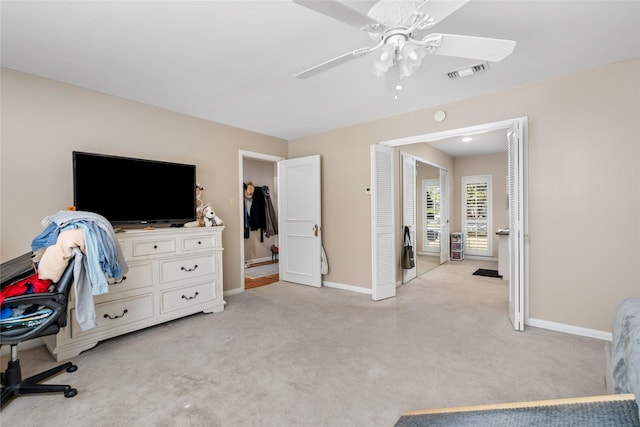 bedroom featuring baseboards, visible vents, a ceiling fan, and light colored carpet