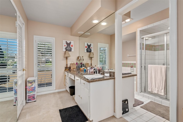 bathroom featuring a stall shower, tile patterned flooring, and vanity