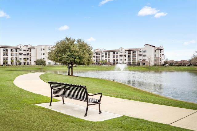 surrounding community featuring a water view and a lawn