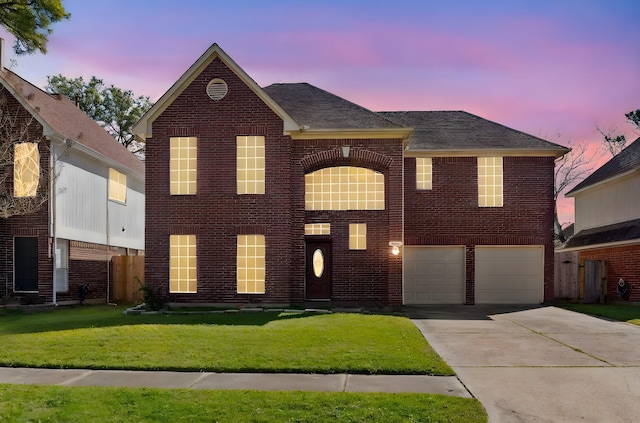 view of front facade featuring brick siding, concrete driveway, and a lawn