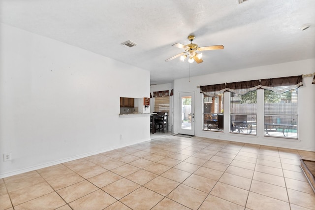 unfurnished living room featuring light tile patterned floors, baseboards, visible vents, ceiling fan, and a textured ceiling