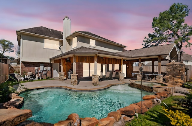 view of pool featuring a pool with connected hot tub, a patio, and fence