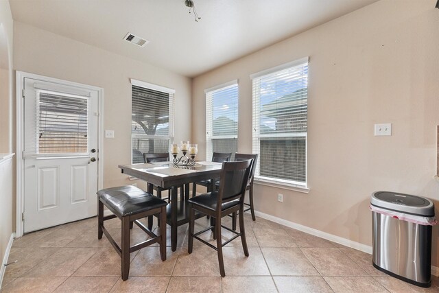 dining room with light tile patterned flooring, visible vents, and baseboards