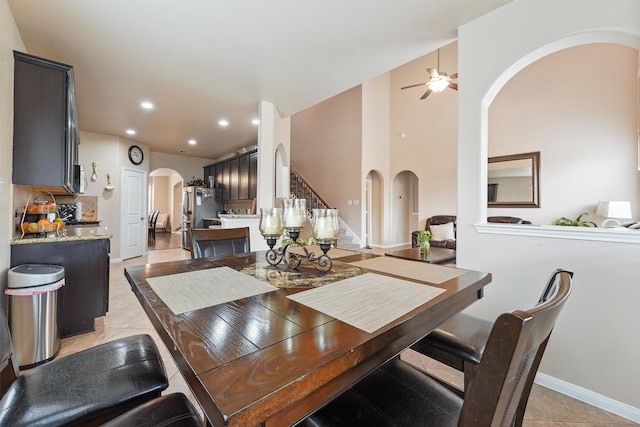 dining area featuring recessed lighting, arched walkways, light tile patterned floors, baseboards, and ceiling fan