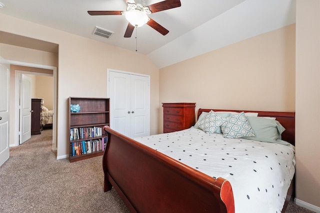 bedroom featuring visible vents, lofted ceiling, a closet, carpet flooring, and baseboards