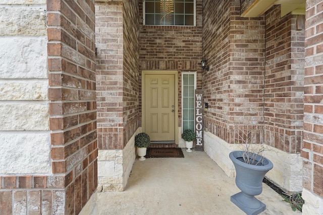 property entrance featuring brick siding