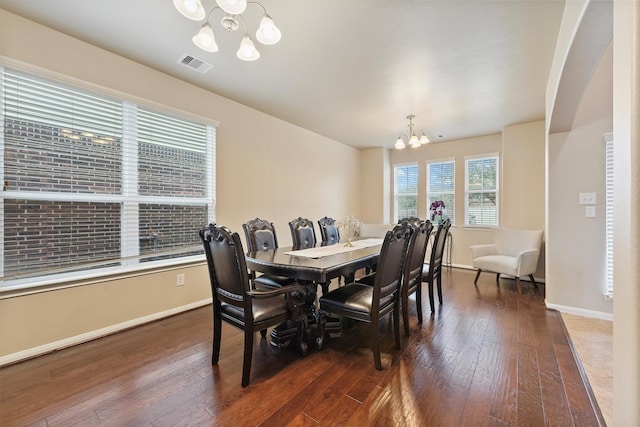 dining room featuring an inviting chandelier, baseboards, visible vents, and wood-type flooring