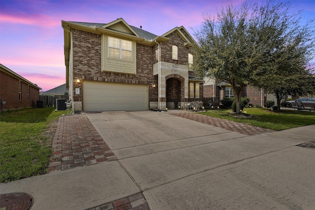 view of front of home featuring brick siding, a front yard, cooling unit, a garage, and driveway