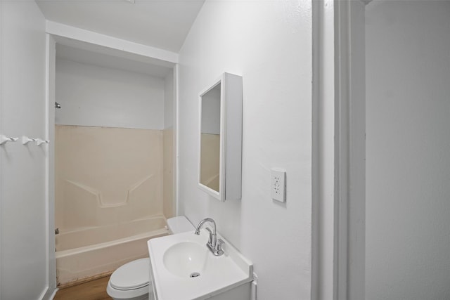 bathroom featuring wood finished floors, toilet, shower / washtub combination, and vanity