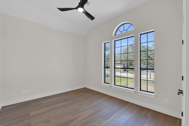 unfurnished room with a ceiling fan, vaulted ceiling, baseboards, and wood finished floors