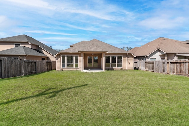 back of property with a yard, roof with shingles, a fenced backyard, and a ceiling fan