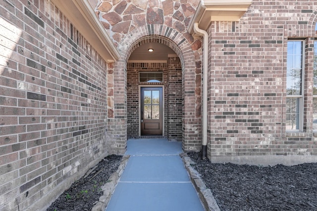 entrance to property featuring brick siding