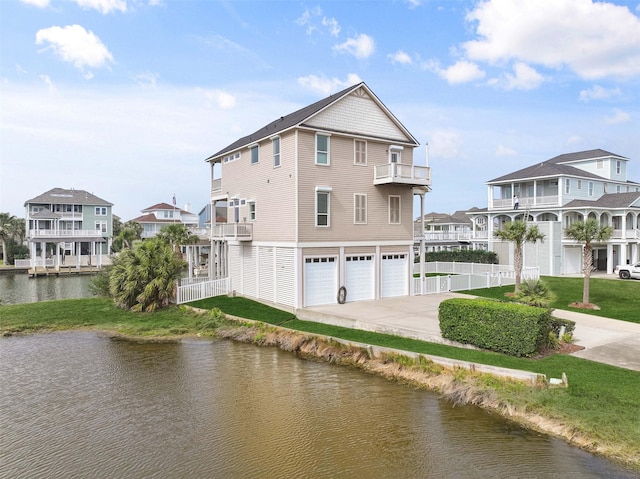 exterior space featuring a water view, driveway, fence, a residential view, and an attached garage