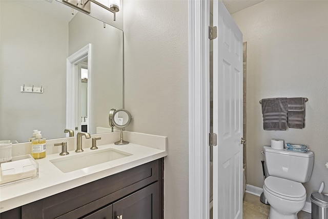 bathroom with vanity, toilet, and baseboards