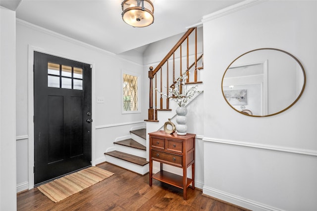 entryway with stairway, baseboards, wood finished floors, and ornamental molding