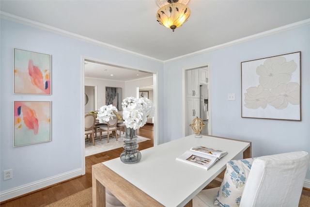 dining space with crown molding, baseboards, and wood finished floors