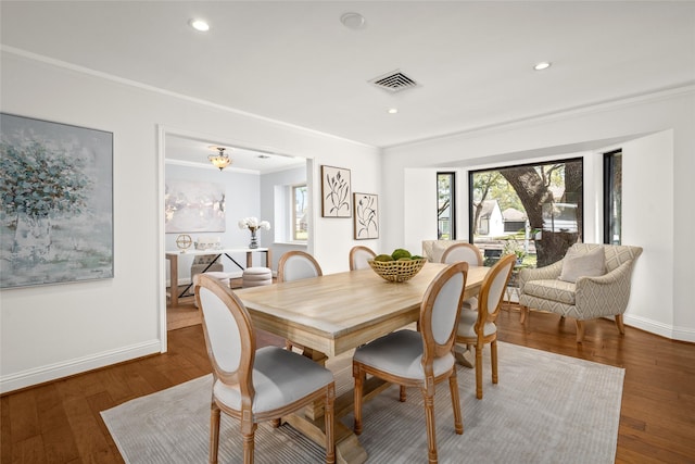 dining room with visible vents, crown molding, baseboards, recessed lighting, and wood-type flooring