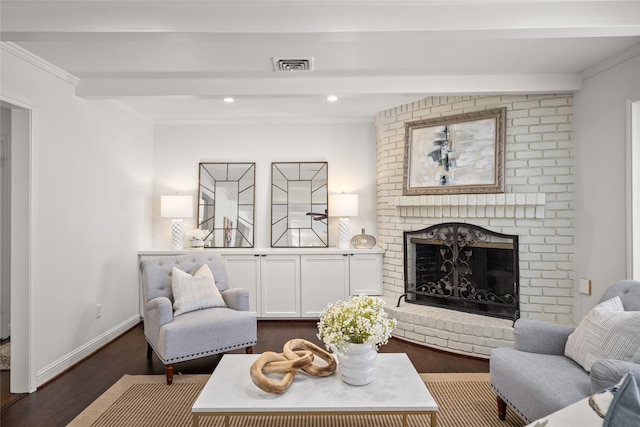 living room featuring visible vents, a brick fireplace, dark wood-type flooring, and ornamental molding