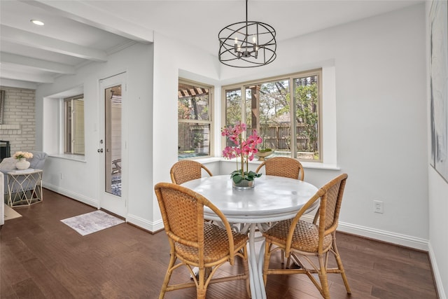 dining space featuring beam ceiling, wood finished floors, and baseboards