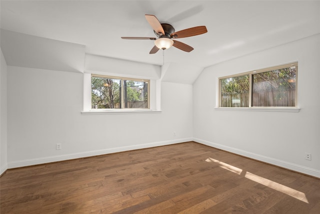 interior space with vaulted ceiling, wood finished floors, baseboards, and a healthy amount of sunlight