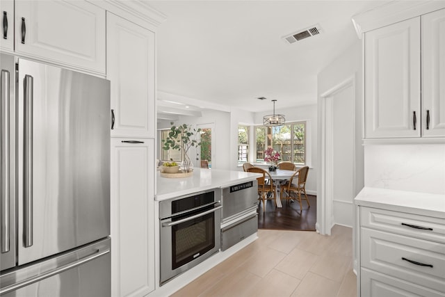 kitchen with visible vents, appliances with stainless steel finishes, light countertops, and a warming drawer