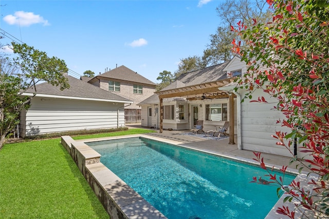 rear view of property with a patio area, a lawn, and a fenced in pool