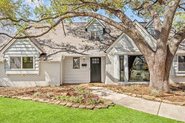 view of front of property featuring brick siding and a shingled roof