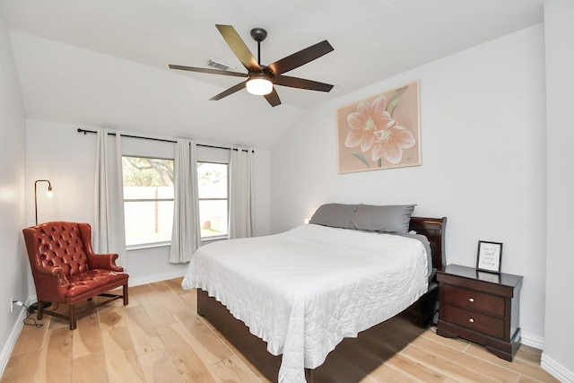 bedroom featuring lofted ceiling, baseboards, visible vents, and light wood finished floors