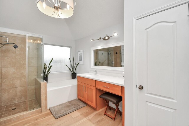 full bathroom with lofted ceiling, a shower stall, vanity, a chandelier, and a bath