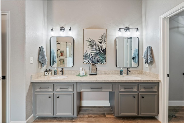 bathroom with wood finish floors, a sink, and double vanity