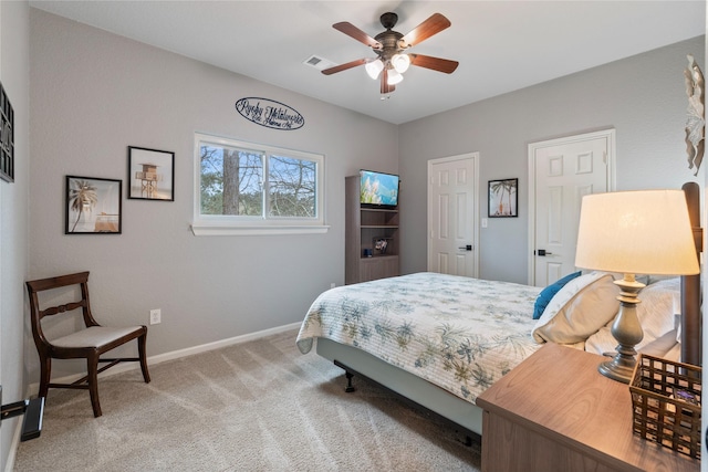 carpeted bedroom featuring ceiling fan, visible vents, and baseboards