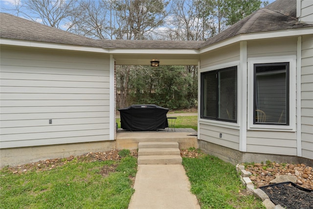 property entrance featuring a shingled roof