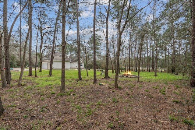 view of yard with a garage and an outdoor fire pit