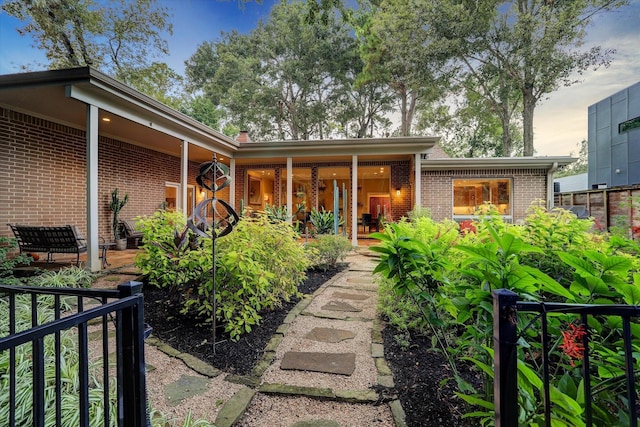 view of front of home featuring a patio area and brick siding