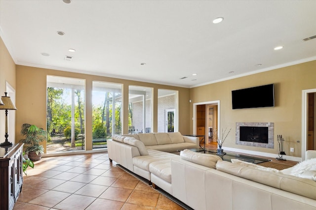 living area with light tile patterned floors, a fireplace, visible vents, and crown molding