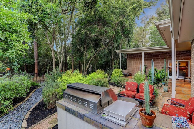 view of patio featuring fence and an outdoor kitchen