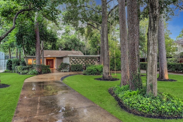 mid-century inspired home with driveway, brick siding, a chimney, and a front yard