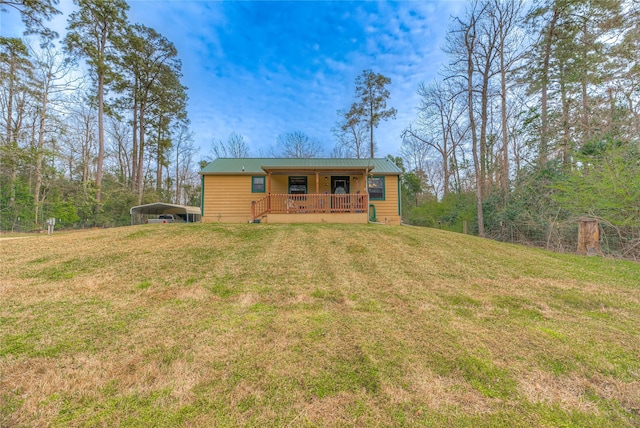 view of front of home with a carport, a front yard, and metal roof