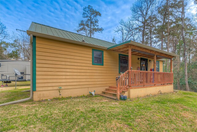 view of front of home with crawl space, metal roof, a porch, and a front lawn