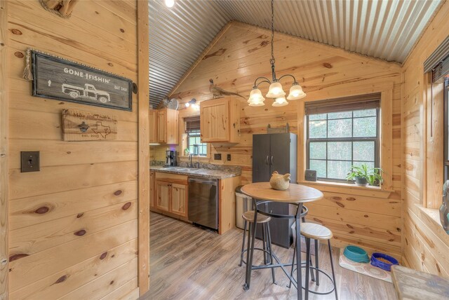 kitchen featuring stainless steel dishwasher, light wood-style floors, light brown cabinets, a sink, and wooden walls