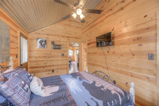 bedroom featuring vaulted ceiling and wooden walls