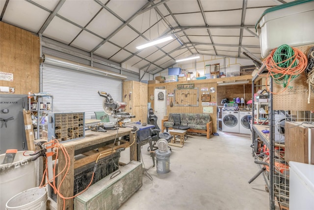 garage with a workshop area, metal wall, and washing machine and dryer