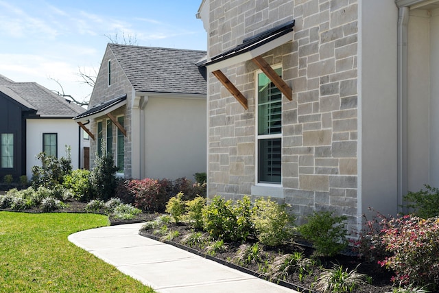 view of home's exterior featuring stone siding, stucco siding, and a shingled roof