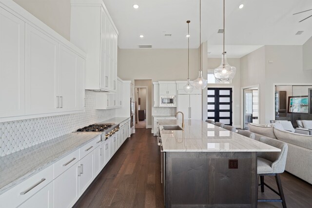 4103 Willowisp Ct, Fulshear, TX 77441 - kitchen with appliances with stainless steel finishes, open floor plan, a breakfast bar, a high ceiling, and dark wood-style flooring