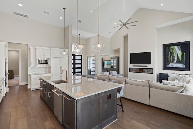 4103 Willowisp Ct, Fulshear, TX 77441 - kitchen featuring stainless steel appliances, high vaulted ceiling, open floor plan, white cabinets, and dark wood-style floors