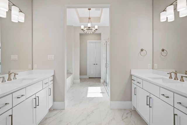 full bath featuring two vanities, marble finish floor, a shower stall, and a sink